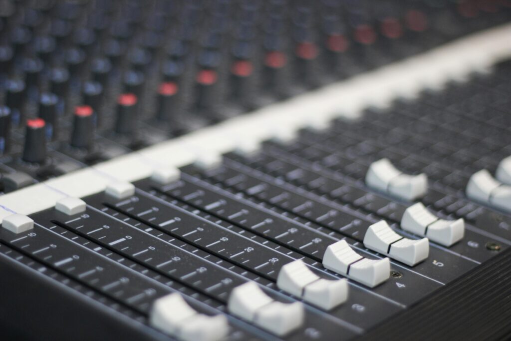 Detailed view of a sound mixer panel with sliders and knobs for audio control.